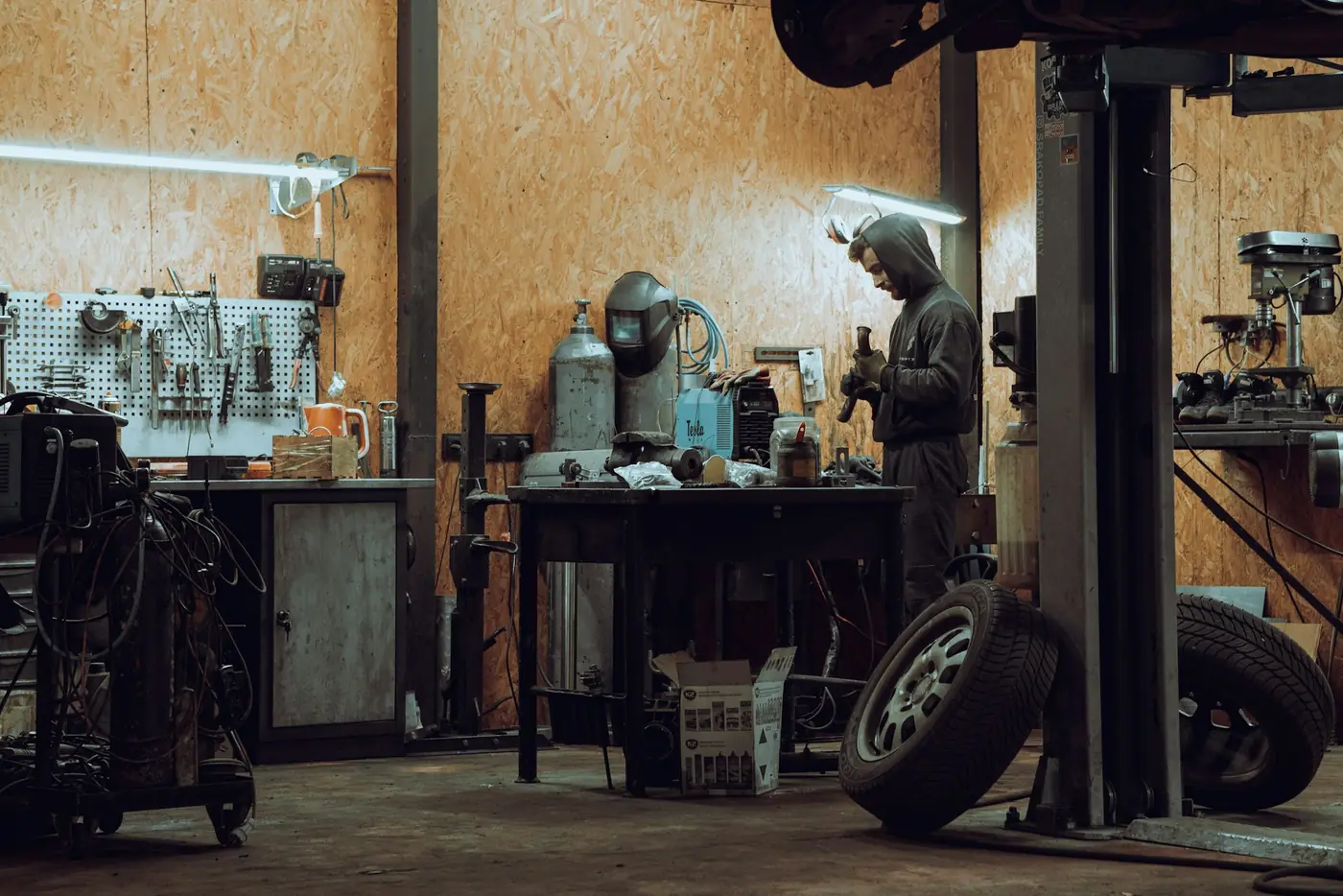 A mechanic working at a bench in a small workshop